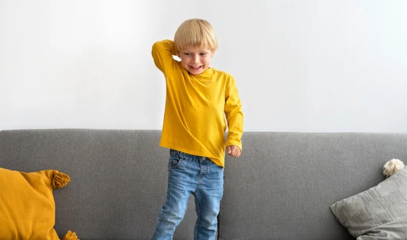 гиперактивный ребенок стоит на диване